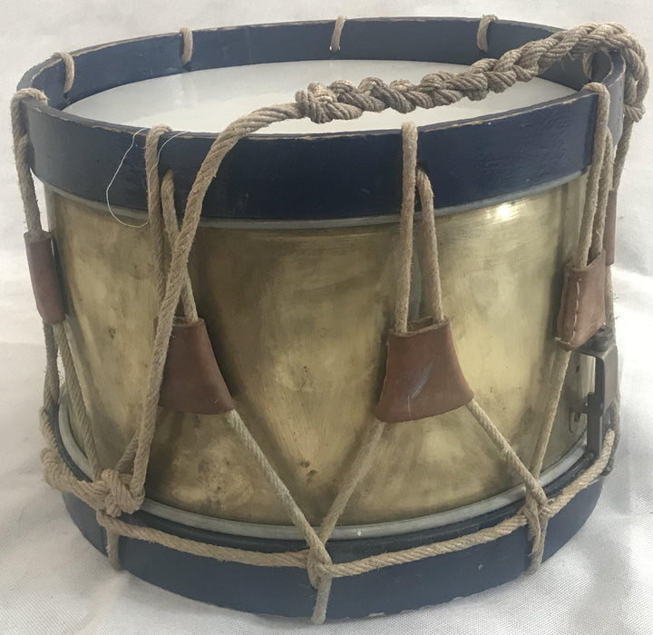 Antique brass drum with blue trim and a rope handle 