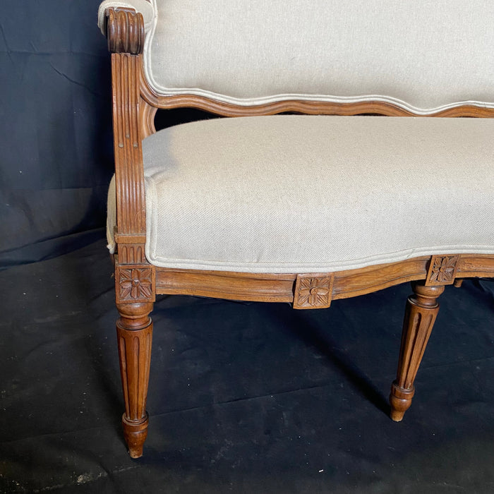 French 19th Century Walnut Louis XVI Hand Carved Sofa Crowned with Superb Block Rosettes