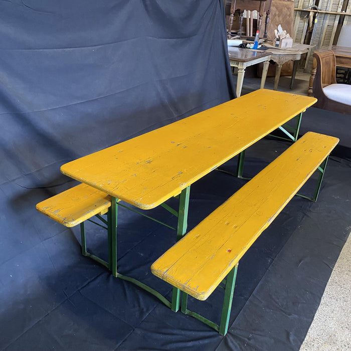 Picnic style yellow painted wood folding table with two benches 