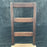 Antique ladder back chair with turned legs and brown upholstered seat 