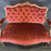 Carved brown walnut loveseat with red upholstery 