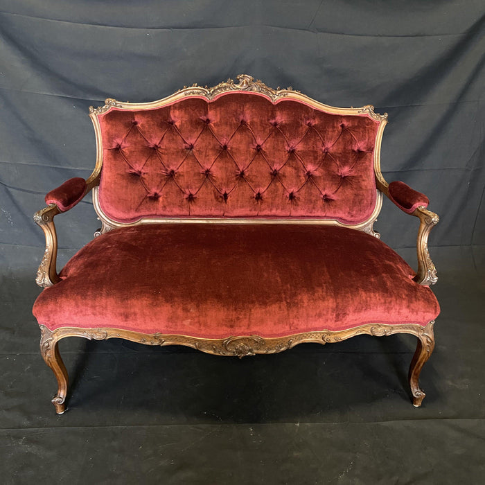 Carved brown walnut loveseat with red upholstery 