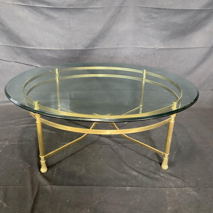 Antique round glass top coffee table with a brass base 