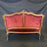 Carved brown walnut loveseat with red upholstery 