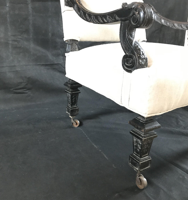 Antique carved armchair on casters with new upholstery 