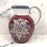 Antique pitcher with purple, blue, white, and gold detailing 